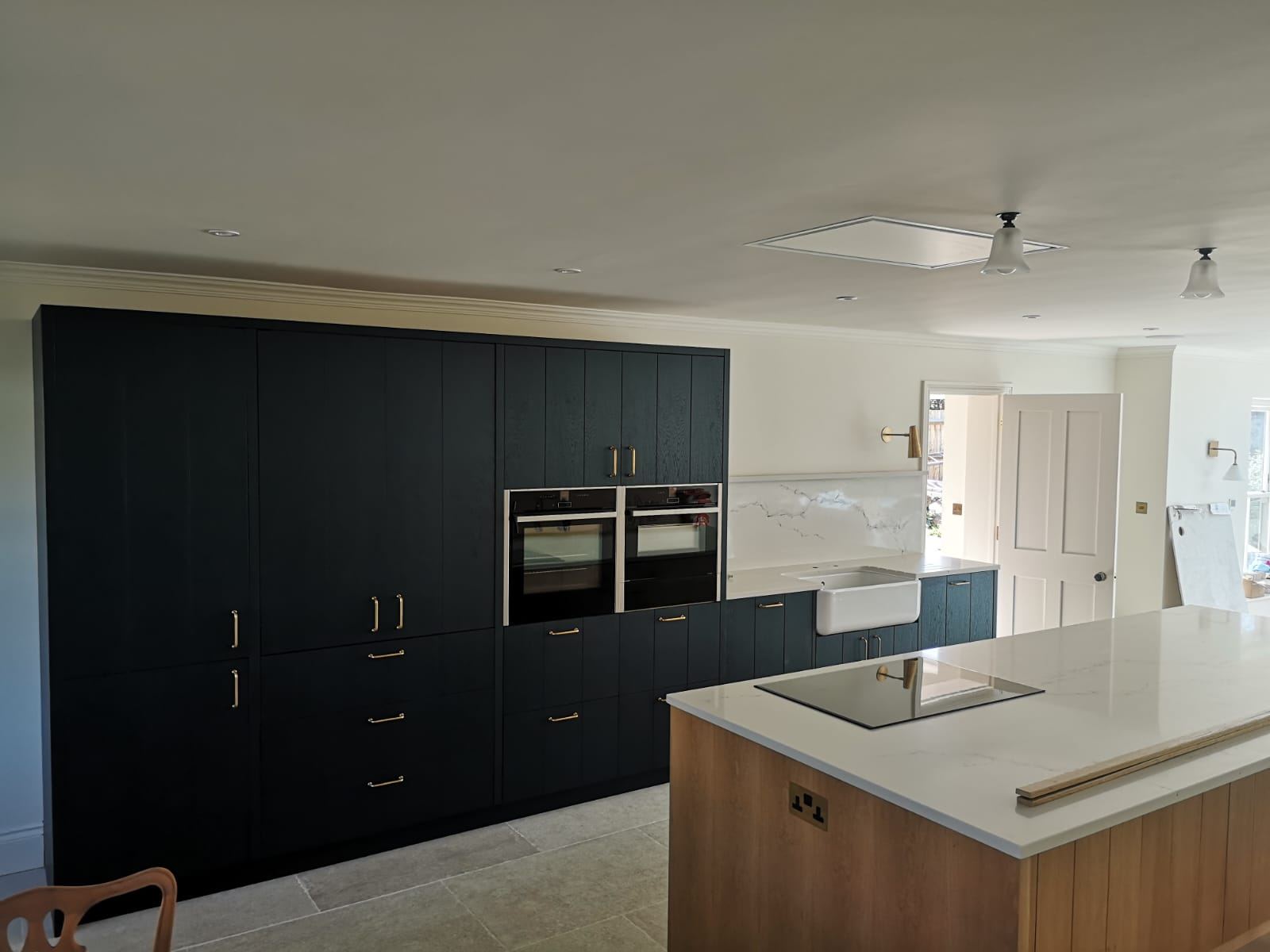 Navy kitchen with brass handles fitted by M Renovations in London