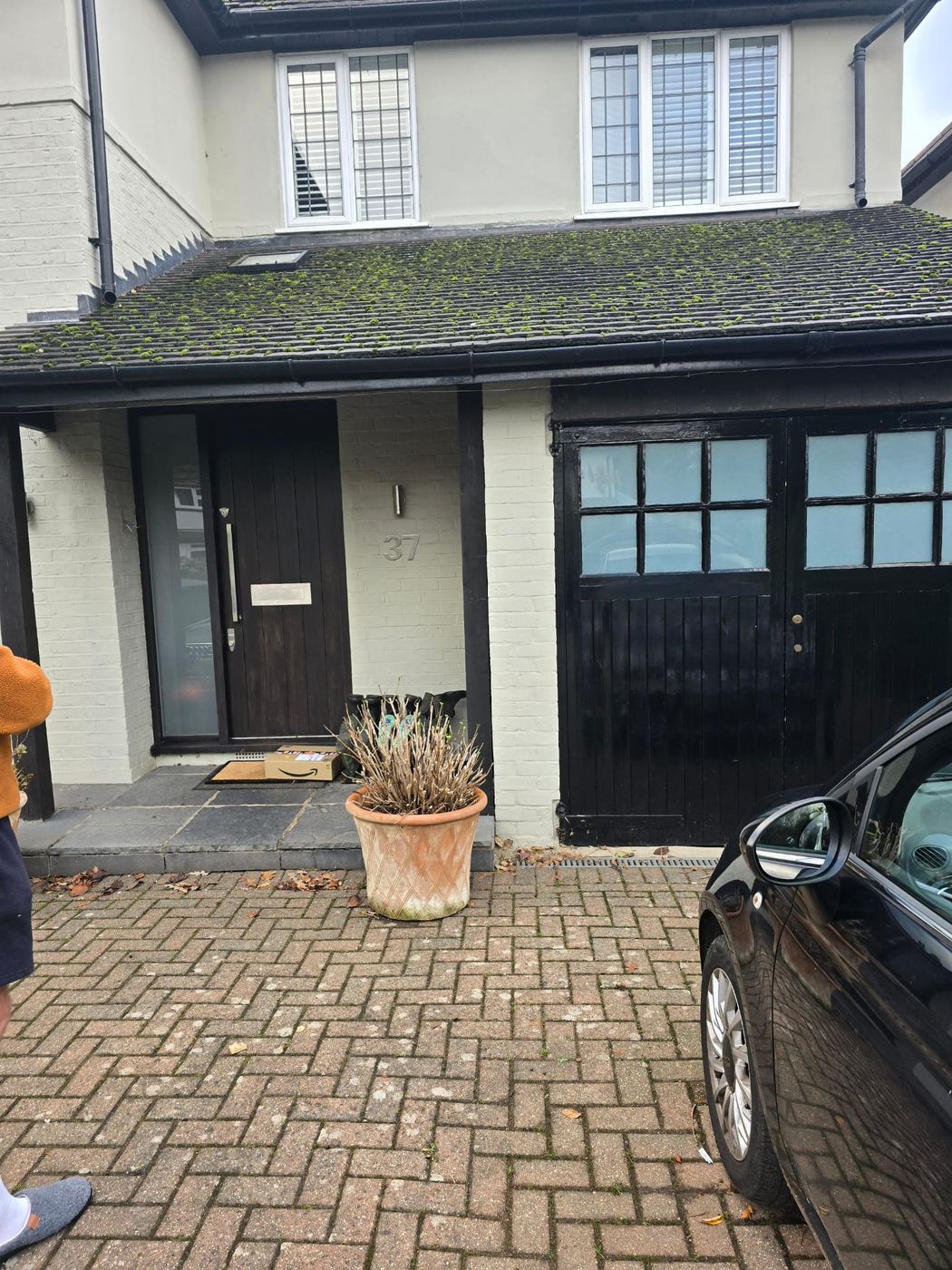 A London house before work started, showing the original garage doors and front entrance under a tiled catslide roof
