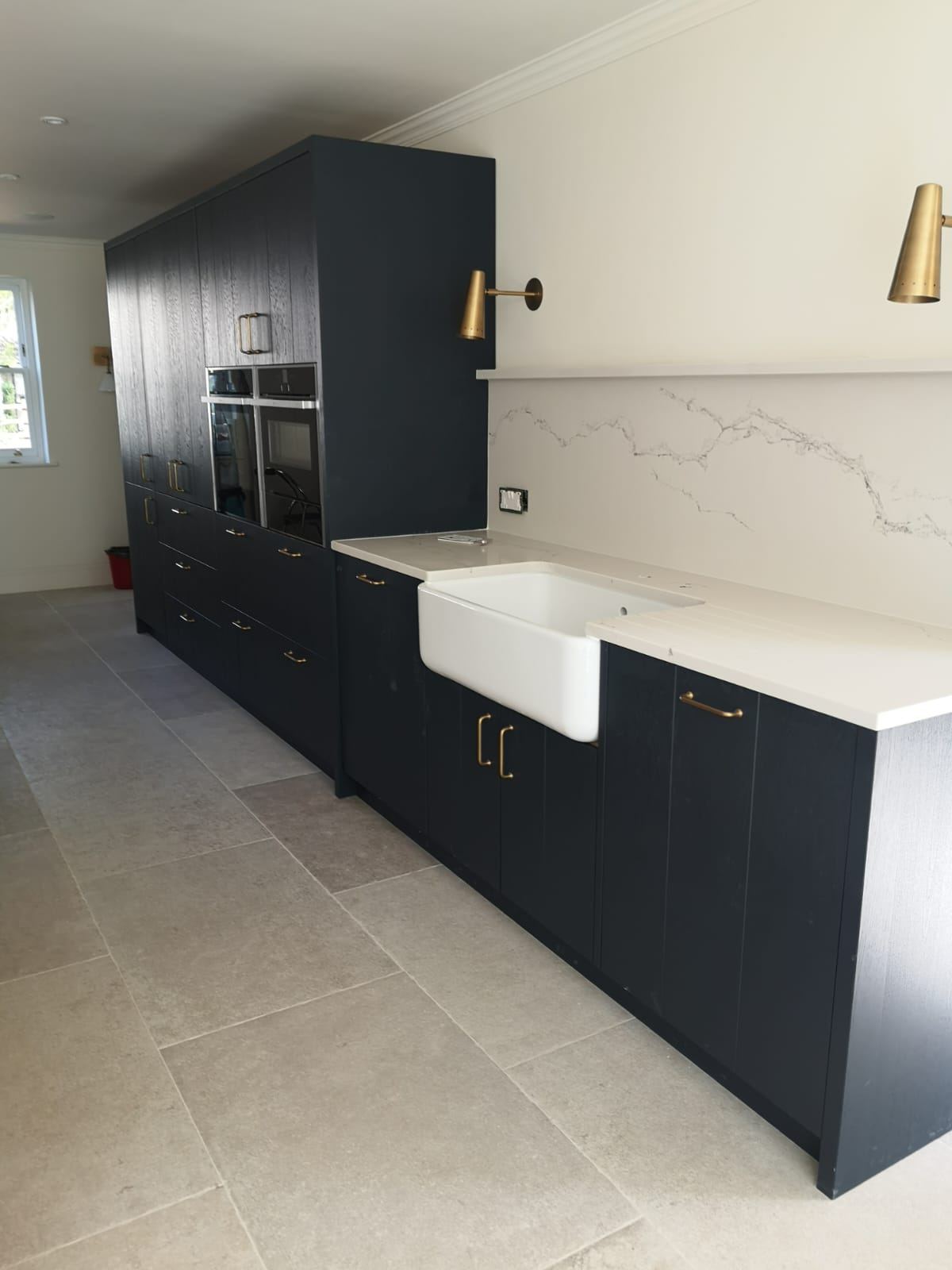 Navy kitchen with brass handles and butler sink